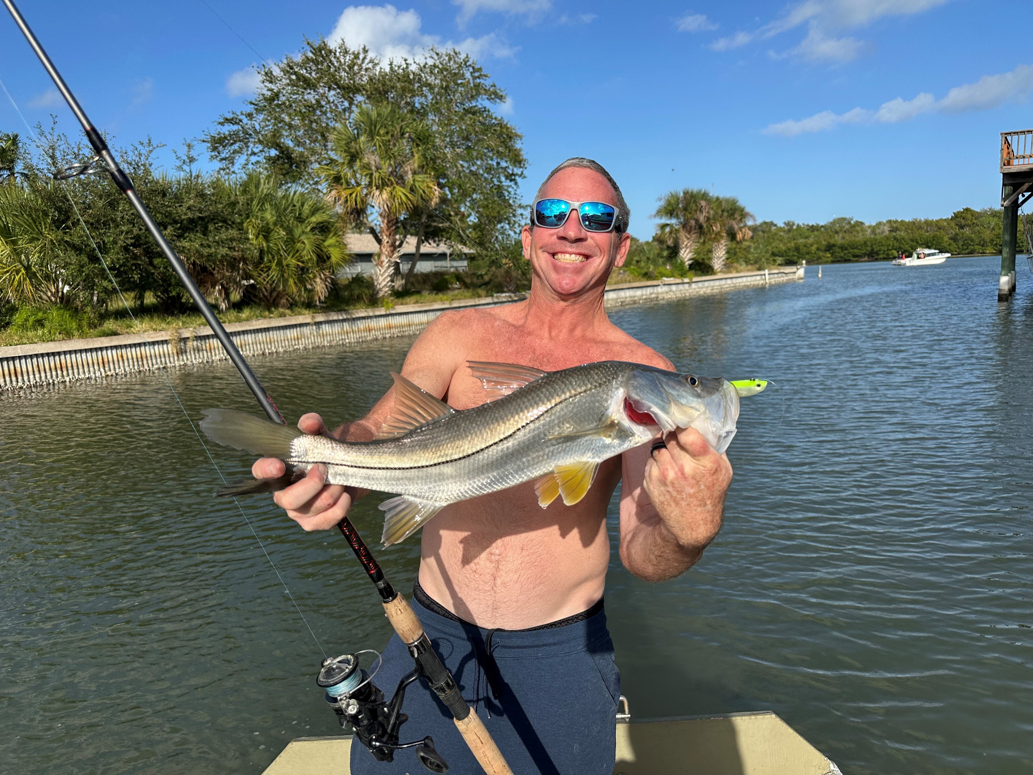 Edgewater Florida snook fishing catch with angler holding a fish in the canal